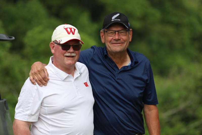 two men standing together smiling
