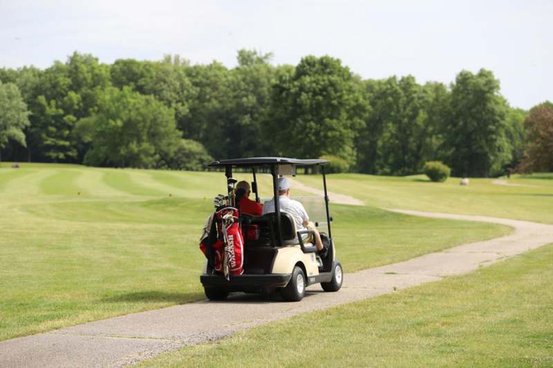 a group of people driving a golf cart
