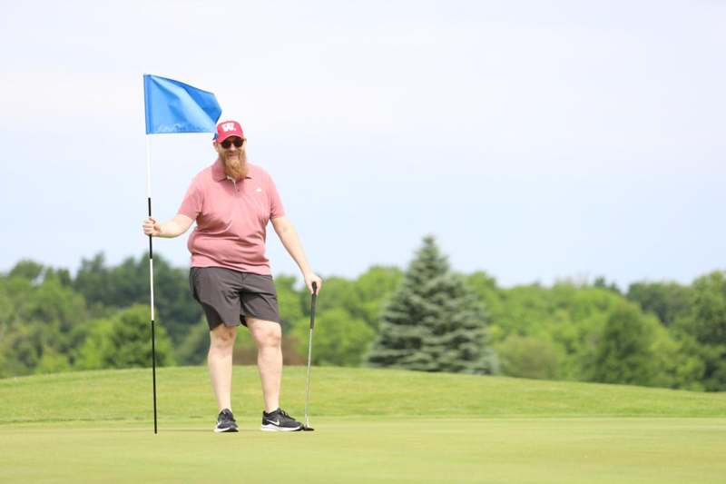 a man holding a flag and a golf club