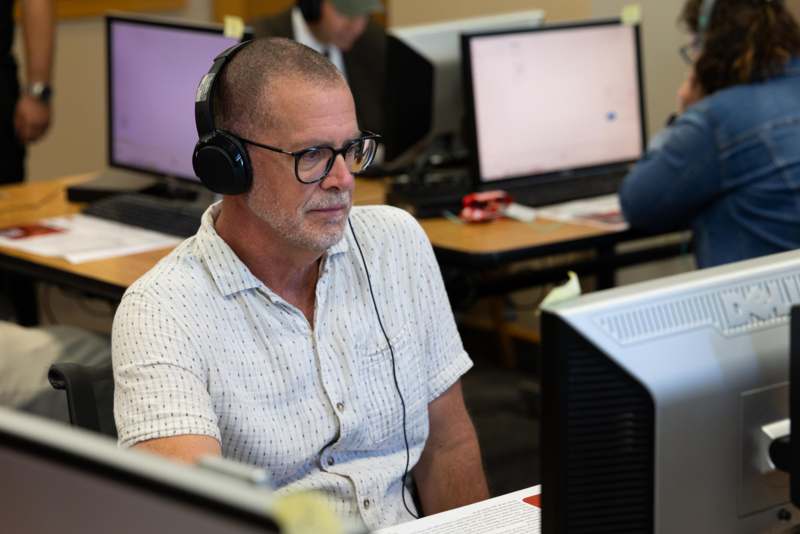 a man wearing headphones and sitting at a desk