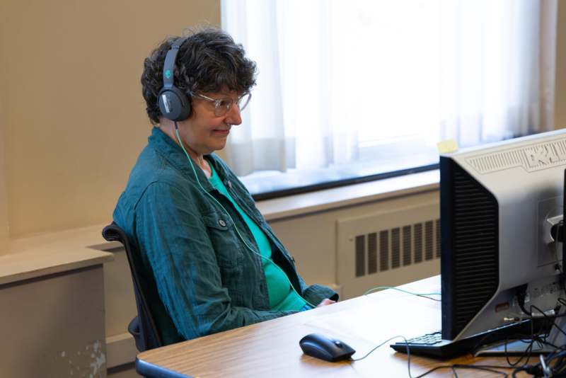 a woman wearing headphones and sitting at a desk