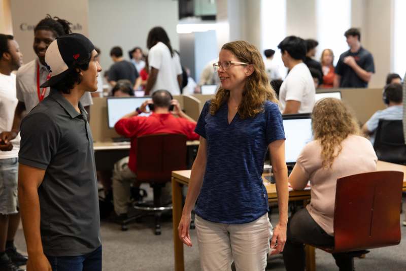 a woman and man in a room with people in the background