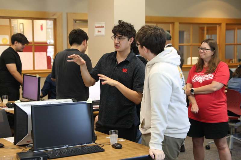 a group of people standing around a computer