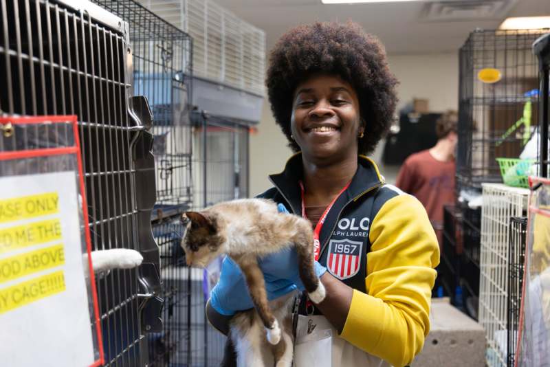 a woman holding a cat in a cage