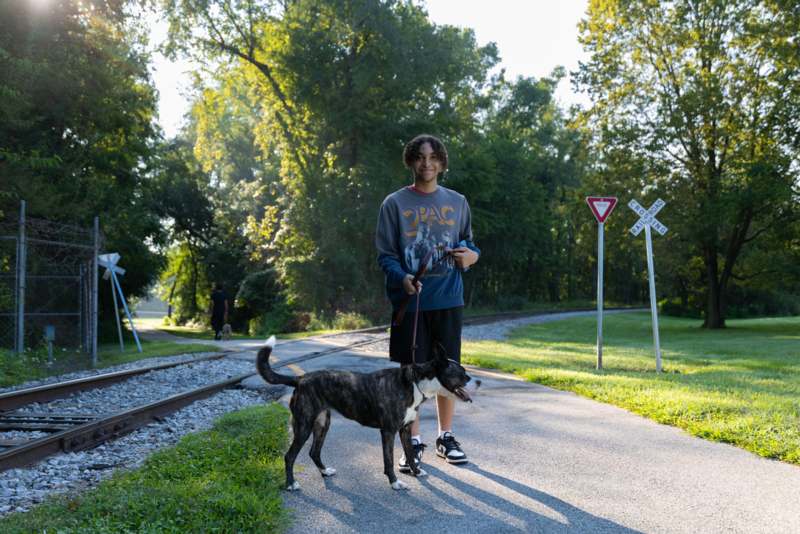 a man standing next to a dog