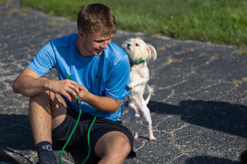 a man sitting on the ground with a dog