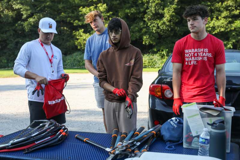 a group of men standing next to a table with tools