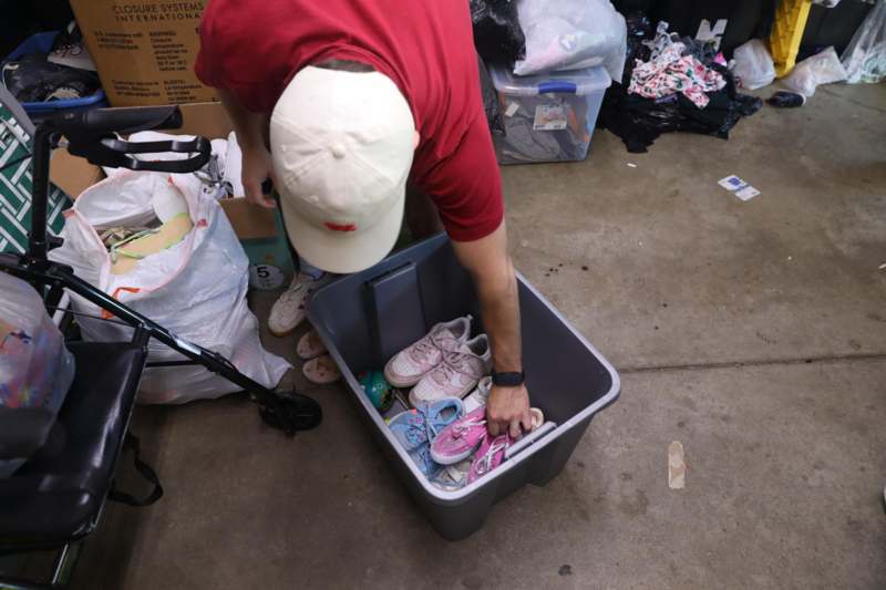 a person putting shoes in a bin