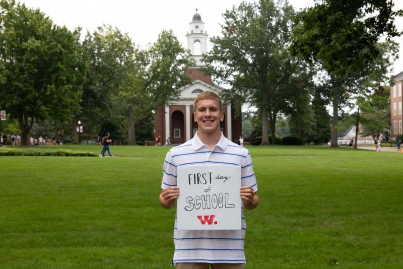 a man holding a sign in front of a building