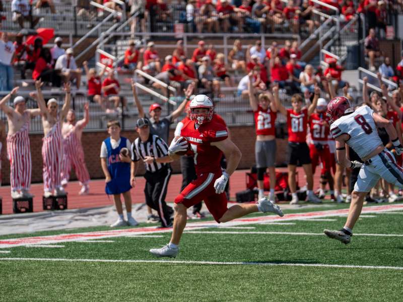 a football player running with a football in the air