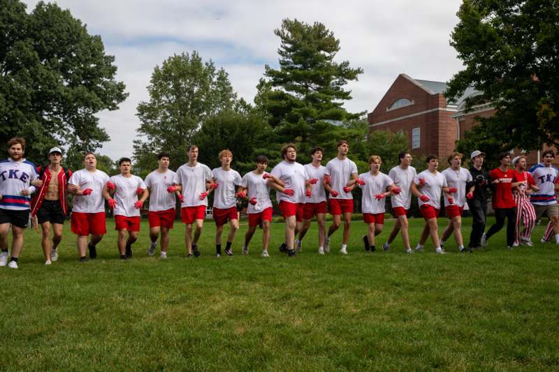 a group of people in white shirts and red shorts