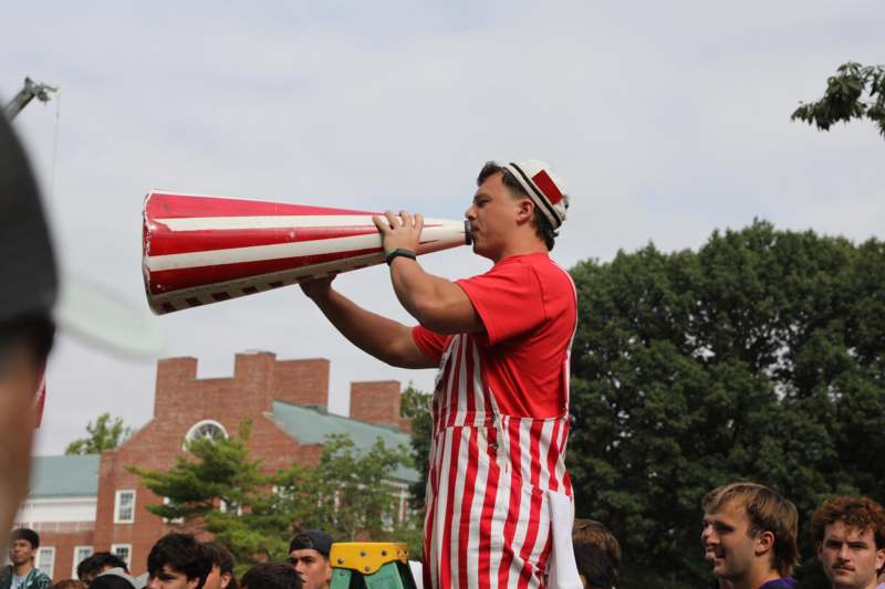 a man in striped apron holding a megaphone