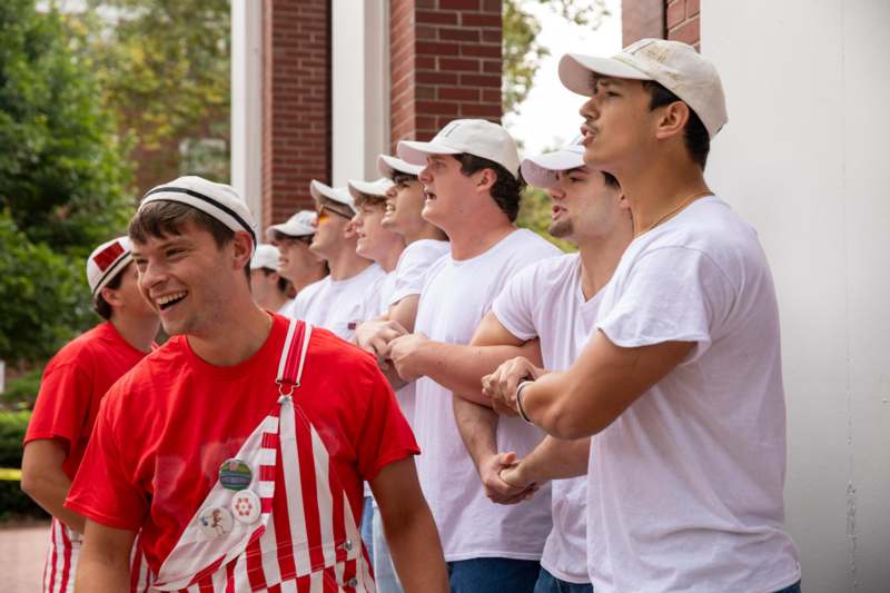 a group of men in white shirts and hats