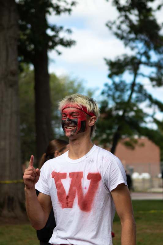 a man with face paint pointing up