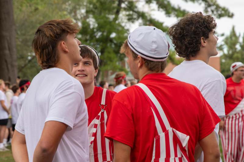 a group of young men in white and red shirts