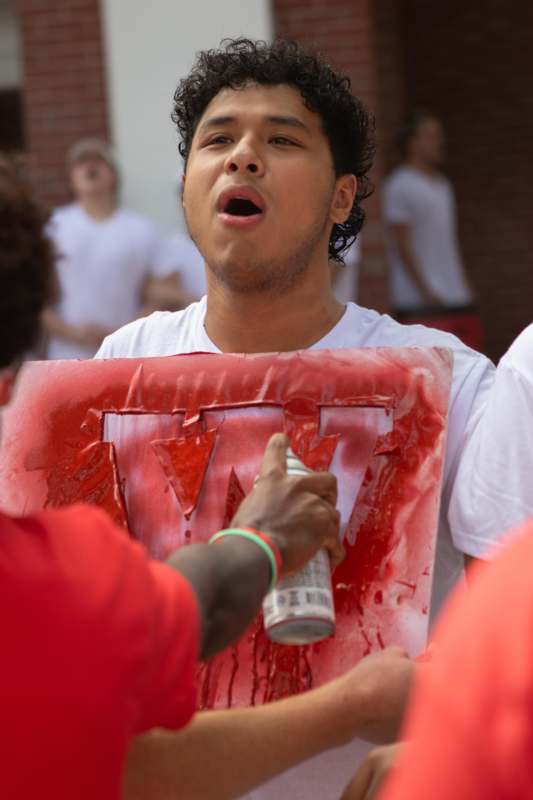 a man holding a spray can and a sign