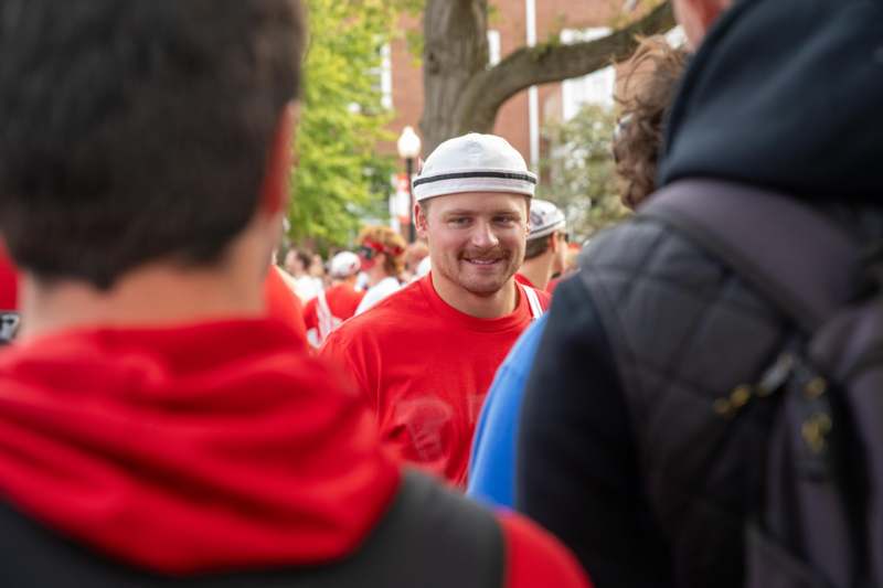 a man in a red shirt and white hat