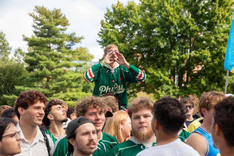 a man in a green jersey standing in front of a crowd of people