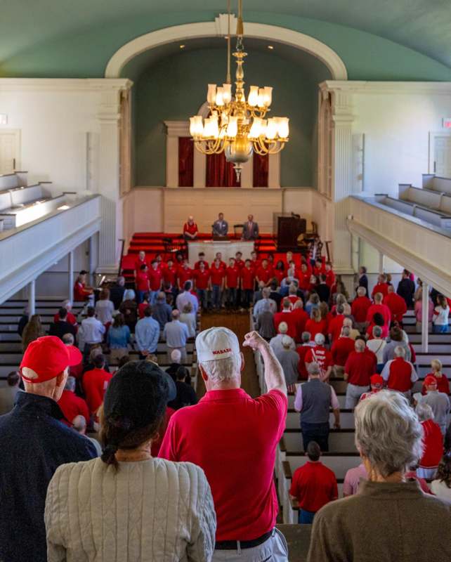 2026 Homecoming Alumni Chapel - a group of people in a room with a chandelier and a man pointing