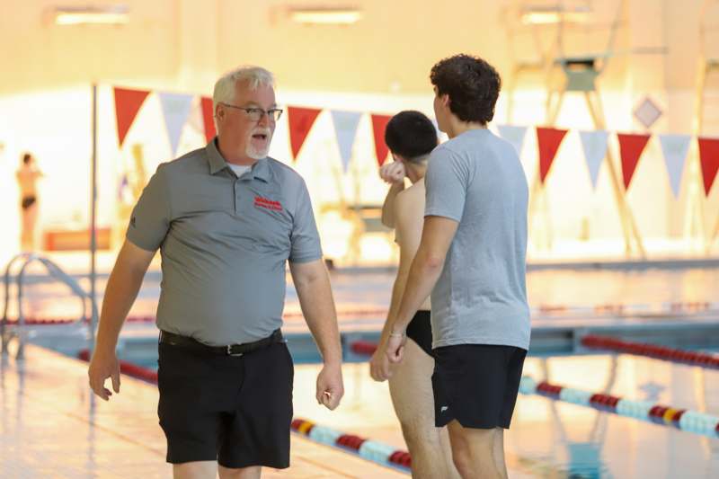 a group of men standing next to a pool