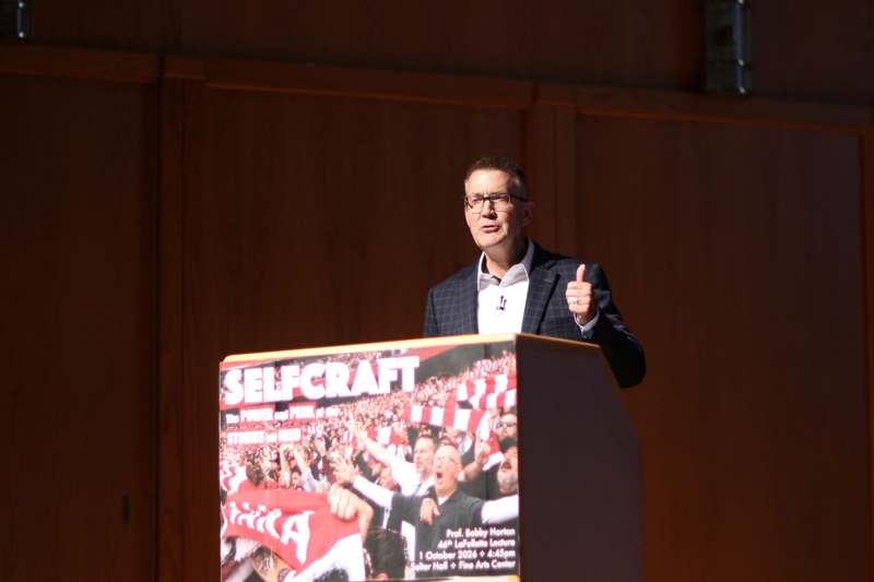 a man giving a thumbs up at a podium
