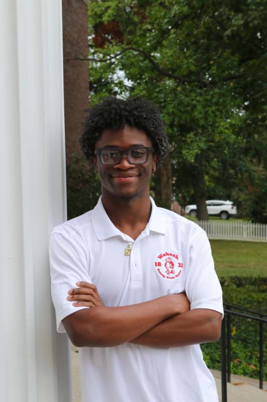 a man with glasses and a white polo shirt