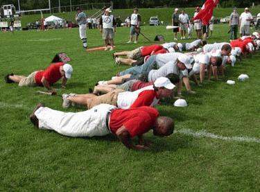 a group of people doing push ups on a field