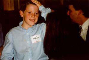 a young boy smiling with a name tag