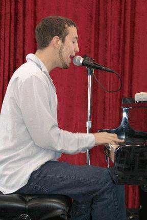 a man playing piano with a microphone