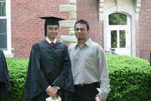 a man standing next to a man in a graduation gown