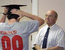 a man putting on a graduation cap