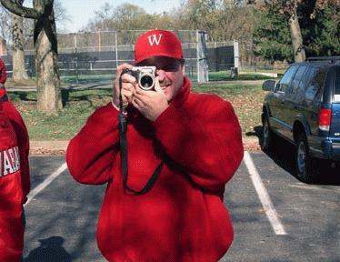 a man in red jacket holding a camera