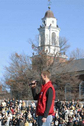a man holding a microphone in front of a church