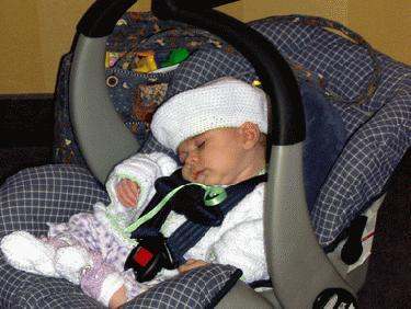 a baby sleeping in a car seat