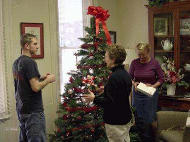 a group of people standing around a christmas tree