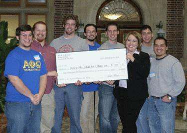 a group of people holding a check