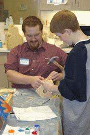a man and boy working on a wood carving